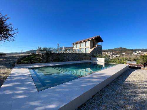 a swimming pool in front of a house at Casa Da Eira 