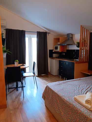 a bedroom with a bed and a table and a kitchen at Porto Centro Station in Porto
