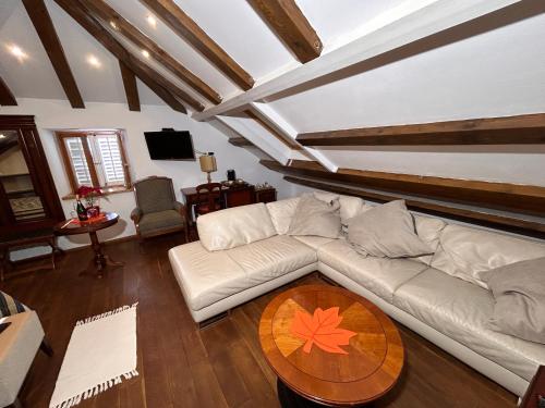 a living room with a white couch and a wooden table at Villa Anica Dubrovnik - luxurious with a sea view in Dubrovnik