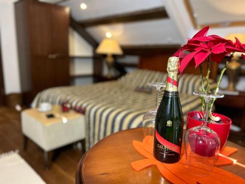 a bottle of wine and a vase with flowers on a table at Villa Anica Dubrovnik - luxurious with a sea view in Dubrovnik
