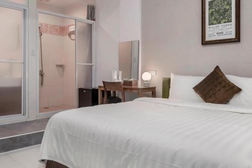 a bedroom with a large white bed and a shower at Sunset Mu Style Inn in Xiaoliuqiu