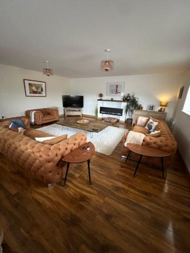 - un grand salon avec un grand canapé et du parquet dans l'établissement Beautiful Modern Farm House (12), à Sheffield