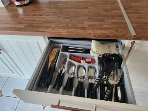 un cassetto pieno di utensili da cucina in cucina di Comfy Guest House a Londra