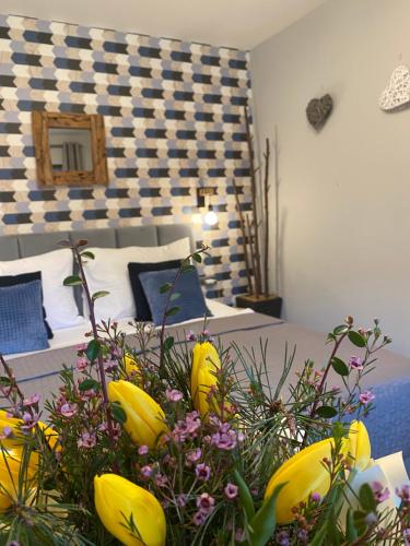 a room with a bed and a bunch of flowers at Resort Lesní Lázně in Zvánovice