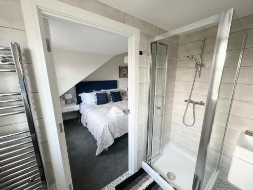 a bathroom with a shower and a bed in a room at No 8 Mathis self-service B&B in Salisbury