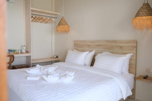 a white bed with three white bowls on it at Nymph Hideout in Ko Phangan