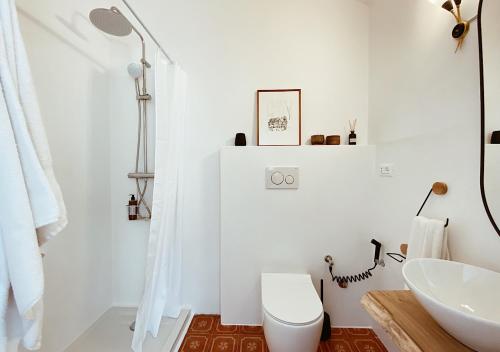 a white bathroom with a toilet and a sink at Casa Dolci Rodolfo 4km from the sea in Montemarciano
