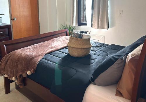 a bed with a blue comforter and a bag on it at Son de Metro Apartment / near Distrito T-Mobile in San Juan