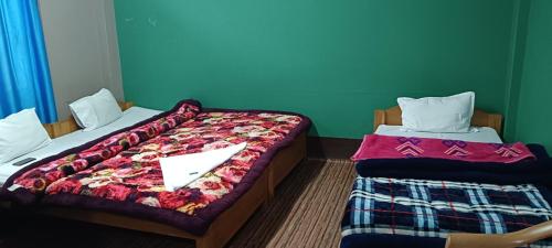two beds in a room with at Aajanta in Tawang