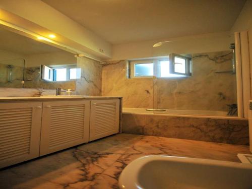 ein großes Bad mit einer Badewanne und einem Waschbecken in der Unterkunft Superb Caminha Villa - 5 Bedrooms - Villa Davidouro - Spectacular Sea and Beach Views in Caminha