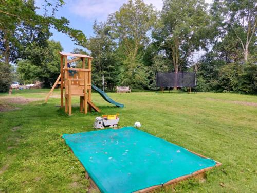 a playground with a slide and a playset at Bell tent Glamping Essenhof in Aagtekerke