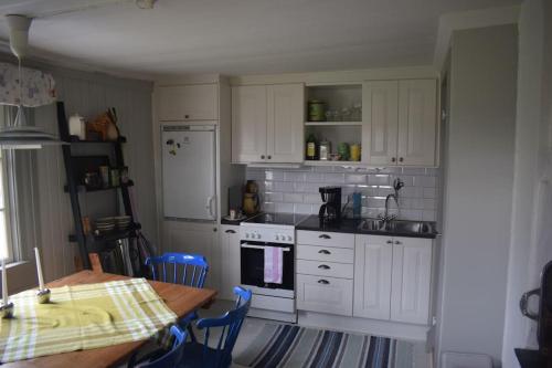 a kitchen with white cabinets and a table and a table and a table at Charming renovated seventeenth century cottage in Ludvika