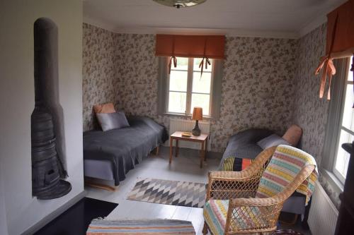 sala de estar con cama y sofá en Charming renovated seventeenth century cottage, en Ludvika