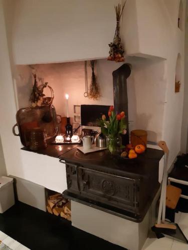 a kitchen with an old stove with flowers on a counter at Charming renovated seventeenth century cottage in Ludvika