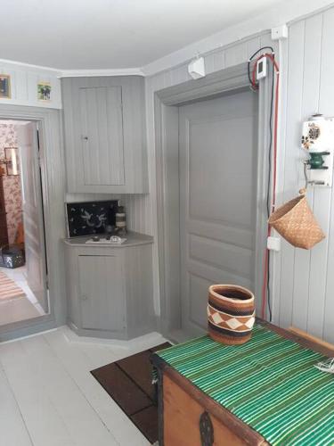 a room with a door and a basket on a table at Charming renovated seventeenth century cottage in Ludvika