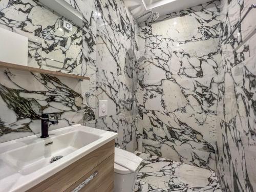 bagno con lavandino e parete in marmo di Rumani 3 Islands Hotel a Ksamil