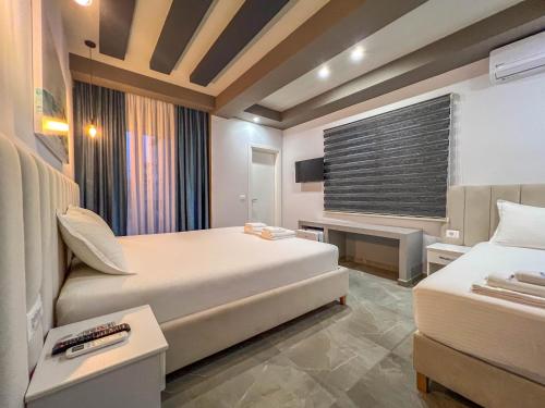 una camera d'albergo con due letti e una televisione di Rumani 3 Islands Hotel a Ksamil