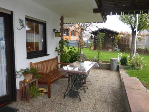 a patio with a table and a bench in a yard at Ferienwohnung bei Rosi in Kirchzell