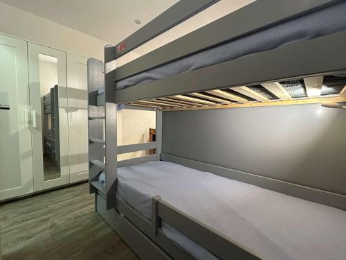 une chambre avec deux lits superposés dans une pièce dans l'établissement Studio confort pour 4 avec terrasse, parking, wifi et animaux admis - FR-1-525-210, à Saint-Étienne-en-Dévoluy