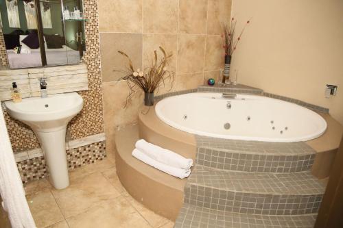 a bathroom with a bath tub and a sink at Moonriver Guesthouse in Upington