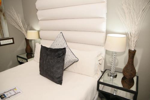a bed with a black pillow and some white towels at Moonriver Guesthouse in Upington