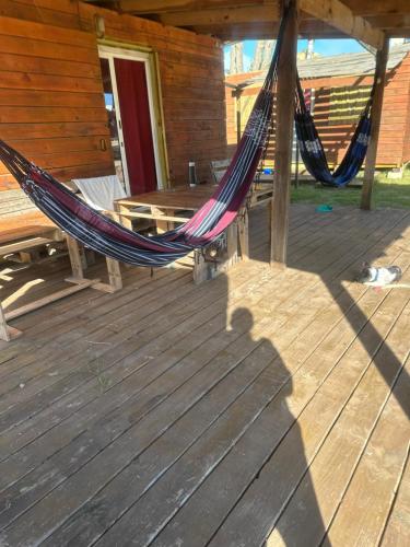 a hammock on the deck of a cabin at dream house in Punta Del Diablo