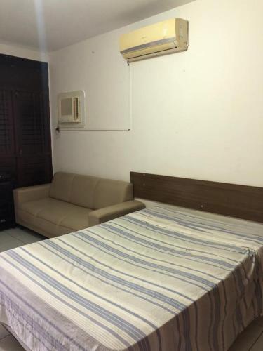 um quarto com uma cama e um sofá em La Playa Hospedagem em João Pessoa