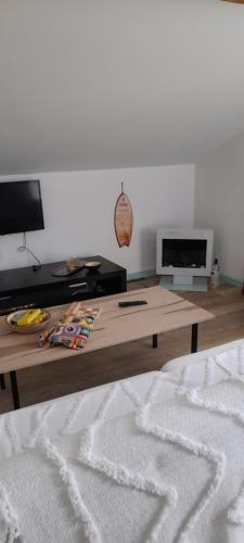 a living room with a coffee table and a flat screen tv at Poolemonhouse in Fernao Ferro