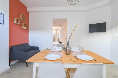 une table à manger avec des chaises blanches et un canapé bleu dans l'établissement Appartement Élégant Arrière Gare, à Arras