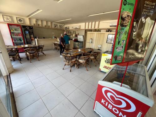 a restaurant with tables and chairs and a coca cola machine at Beach Living Vista Mar - 3 Quartos - Pé na Areia in Aquiraz