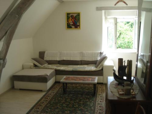 een woonkamer met een bank en een tafel bij Les Basses Rouves Niort in Lassay