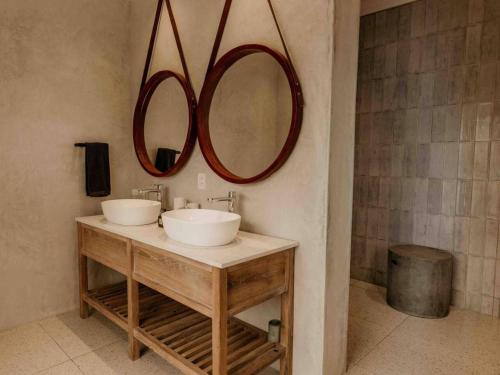 a bathroom with two sinks and two mirrors on the wall at Fancy Fritz B&B in Swakopmund