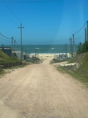 a dirt road leading down to the beach at dream house in Punta Del Diablo