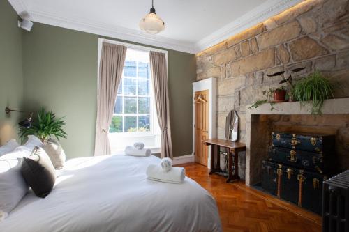 a bedroom with two beds and a stone wall at Ashton View in Glasgow