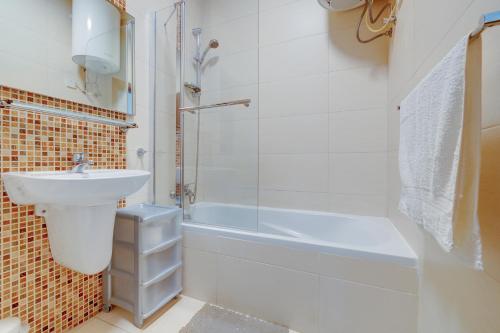 een badkamer met een wastafel, een bad en een douche bij Tranquil Retreat Steps from St Julians Action in St Julian's