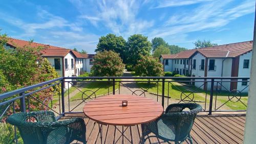 einen Holztisch und Stühle auf einer Terrasse in der Unterkunft Hotel Ostseeland in Warnemünde