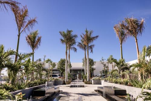 een loopbrug met palmbomen voor een gebouw bij Servatur Puerto Azul in Puerto Rico de Gran Canaria