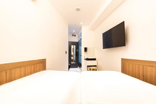 ソウルにあるU STAY MyeongDongのベッドルーム1室(ベッド2台、薄型テレビ付)