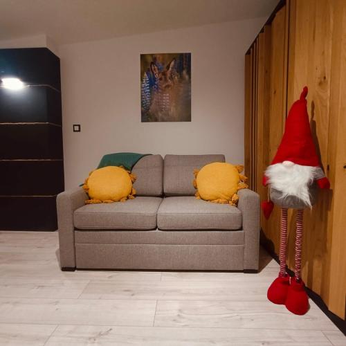 a room with a santa claus standing next to a couch at Studio z sauną in Duszniki Zdrój