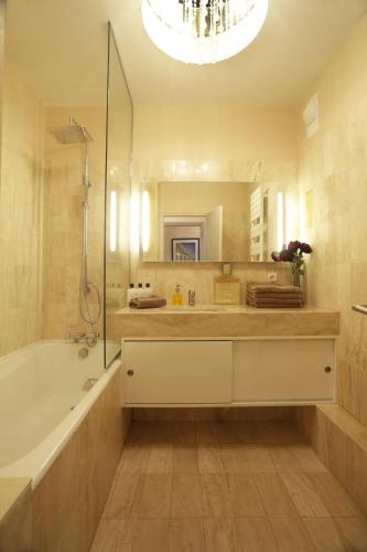 une salle de bain avec une baignoire et un grand miroir dans l'établissement LE PANORAMIQUE, à Deauville