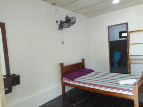 1 dormitorio con 1 cama y reloj en la pared en Wilpattu Buma Homestay, en Pahala Maragahawewa