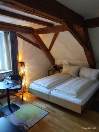 a bedroom with a large bed and a table at Gasthaus "Hotel Hirschen" in Beromünster