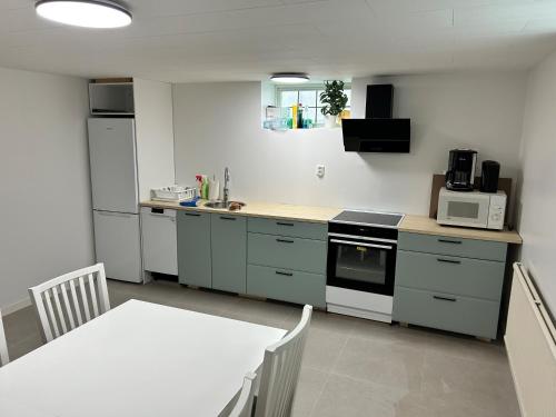 una piccola cucina con tavolo e forno a microonde di Vrigstad Rumshotell a Vrigstad