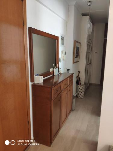 a bathroom with a large mirror and a wooden dresser at Fay's home in Thessaloniki