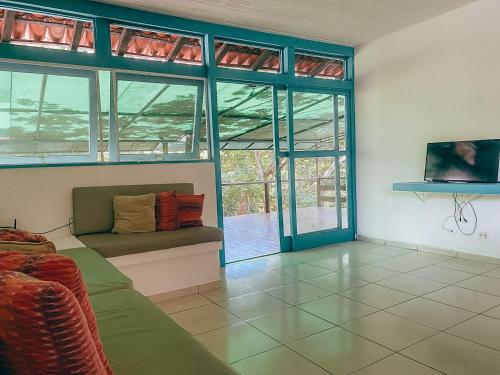 een woonkamer met een bank en een aantal ramen bij Buzios Praia Caravelas cs 11 in Baía Formosa