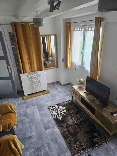 a living room with a tv and a table at Purple Baroque Rer C -N104-A6 in Brétigny-sur-Orge