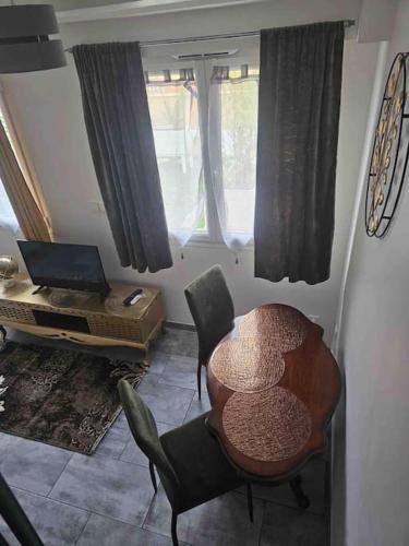 a living room with a table and chairs and a laptop at Purple Baroque Rer C -N104-A6 in Brétigny-sur-Orge