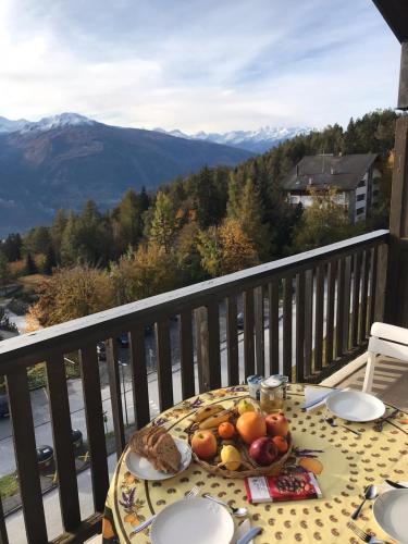 a table with a plate of fruit on a balcony at Crans Montana spacious 80m2 apartment with stunning view & bus stop outside in Crans-Montana