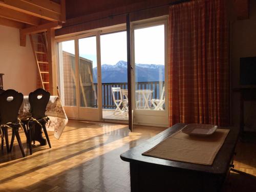 a living room with a view of a balcony at Crans Montana spacious 80m2 apartment with stunning view & bus stop outside in Crans-Montana