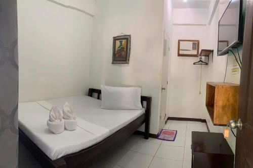 a small bedroom with a bed with two white pillows at Lang2 place in Coron